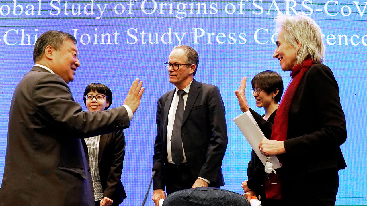 Peter Ben Embarek (al centro) e Marion Koopmans (a destra) salutano la loro controparte cinese Liang Wannian (a sinistra) dopo la conferenza stampa del 9 febbraio per discutere i risultati di un'indagine congiunta sulle origini della pandemia. FOTO AP/NG