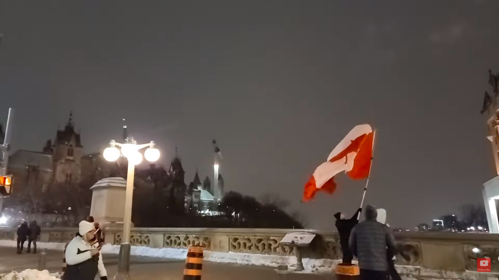Adesso a Ottawa manifestante sventola bandiera sul ponte Alexandra gridando 'Freedom!'