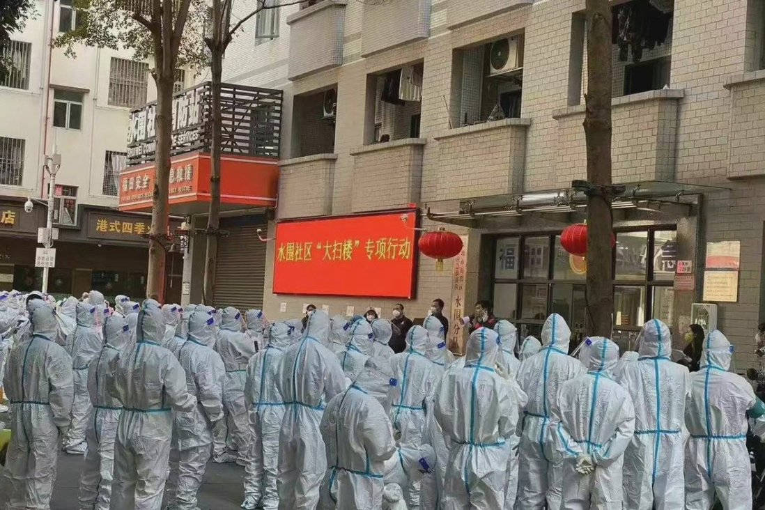 Residenti di Shuiwei, al confine con Hong Kong, in attesa di essere tamponati e contati per membri del nucleo familiare